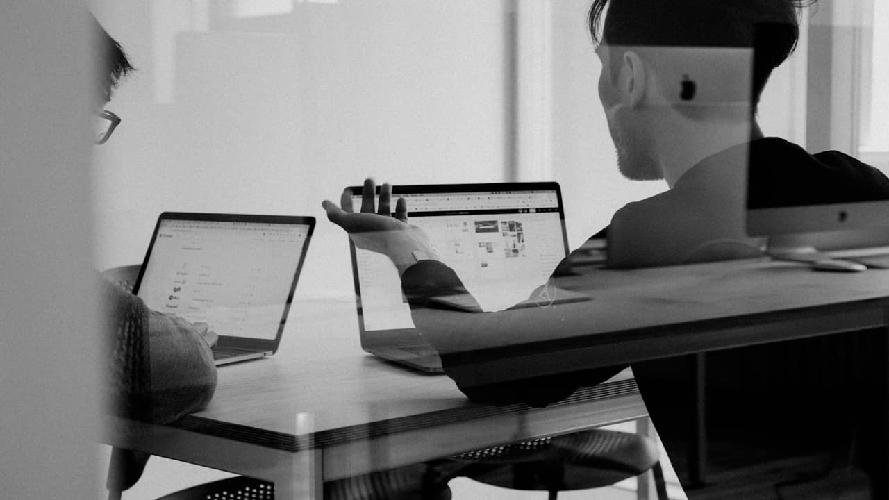 A person working on a laptop in black and white