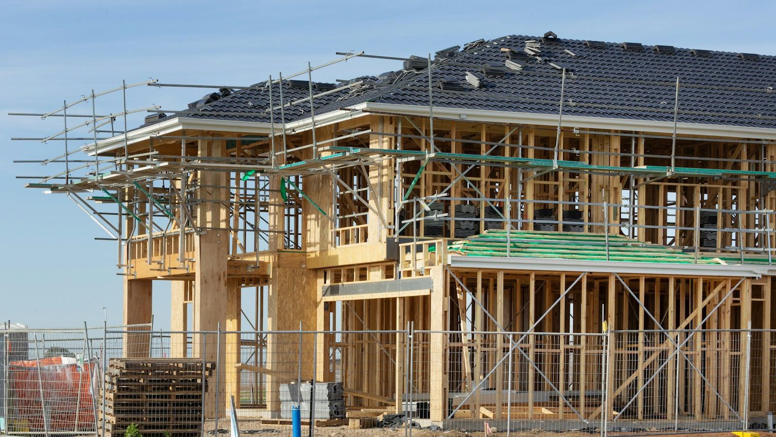 A wood-framed house under construction with scaffolding