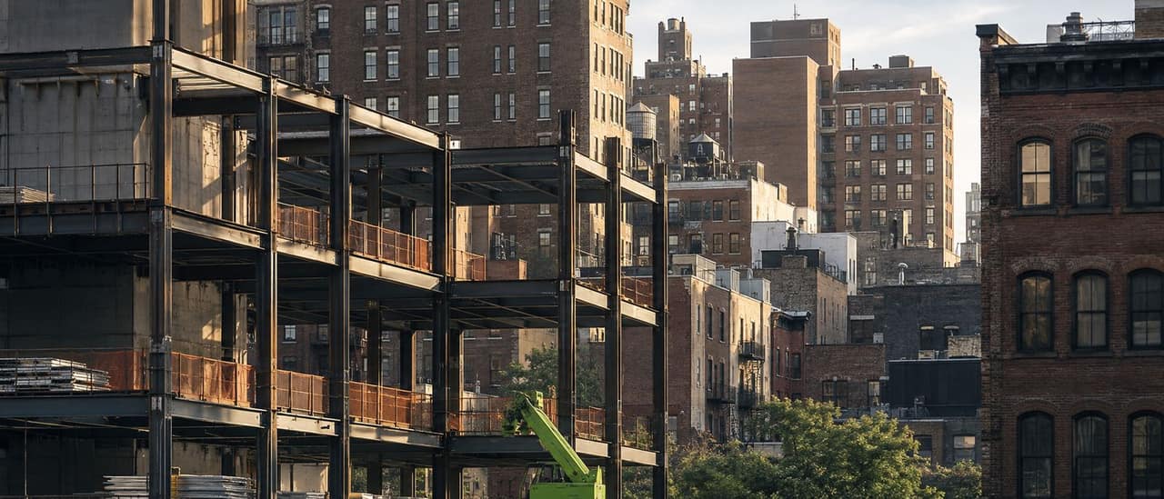 Buildings under construction between older New York apartment blocks
