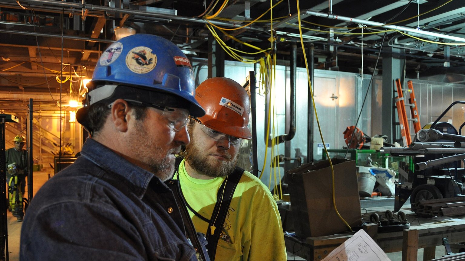 Sheet metal crew installing ductwork in a building under construction