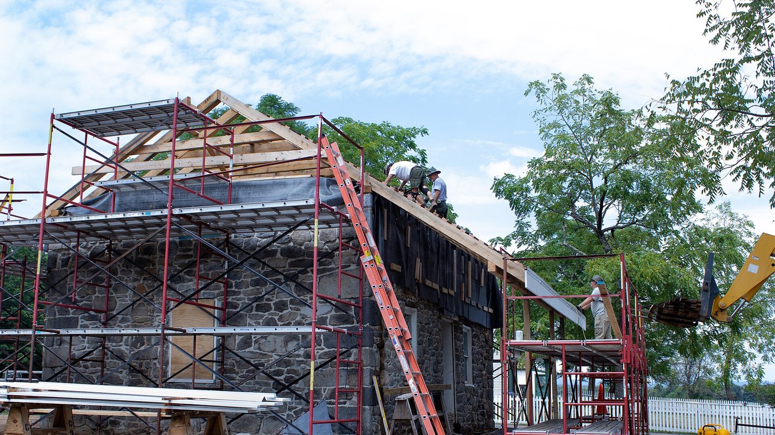 Roofers installing shingles on a new residential roof deck